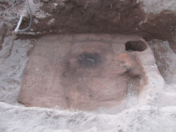 <em> The base of the Romero house horno. The bricks are fired bright red from the extreme heat of the oven (photograph by Homer Thiel).</em>