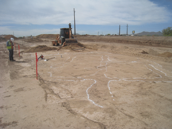 Photo of Early Cienega agricultural fields under the southbound I-10 frontage Road being exposed with a backhoe. The berms and feeder canals of “waffle garden” fields are outlined with spray paint so that they can be mapped. 