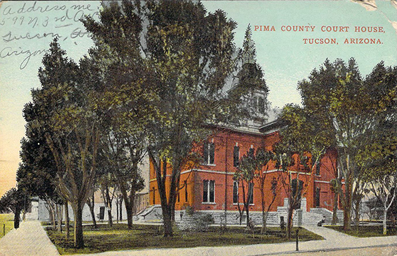 Vintage postcard showing the 1881 Pima County Courthouse. A yellow area in the lawn on the left side was the location of the cesspool.