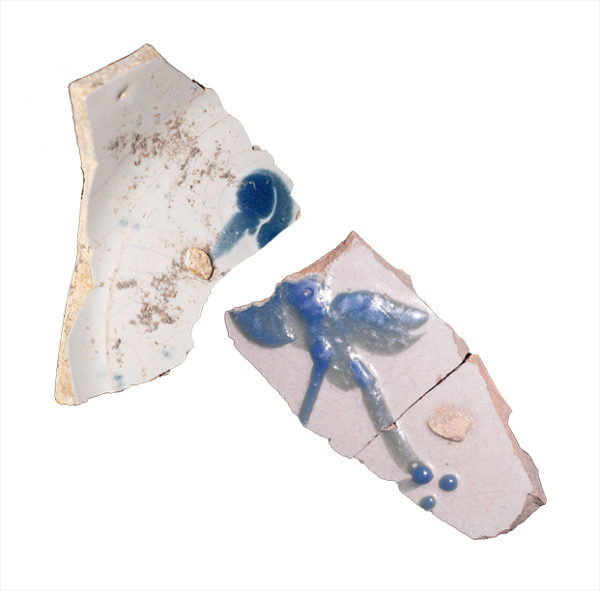 Photograph of two blue-on-white majolica plate sherds with a bird design.