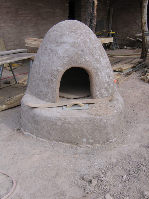 The bread oven at the Presidio Museum under construction in 2007. The oven is a squat beehive shape, covered in stucco, with a small arched opening in front. 